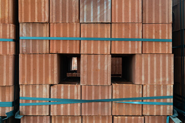 Red brick pallets are stored in an open area. Close-up shot.
