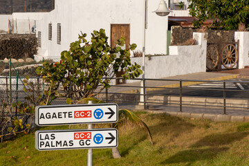 Fototapeta na wymiar Road traffic sign in Puerto de las nieves, Gran Canaria, Spain. Traditional white Spanish buildings in background