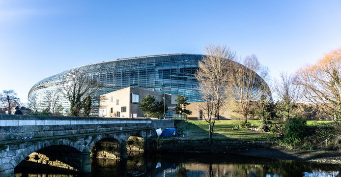 A homeless person's tent along the banks of The Dodder River, near Lansdowne Road, Dublin, Ireland, against the backdrop of the Aviva Stadium.