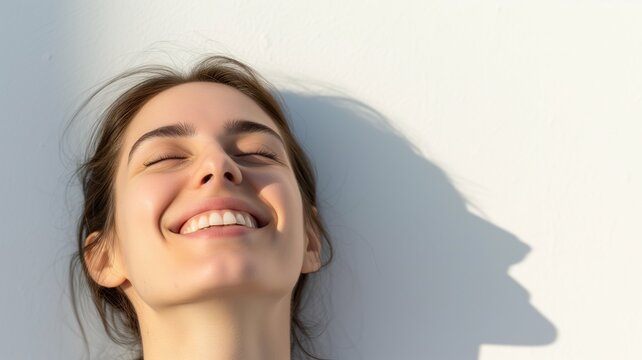 A radiant image of a young woman with a joyful expression, basking in sunlight