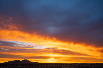 Mojave desert at sunrise with vivid orange and purple clouds, aerial view, timelapse