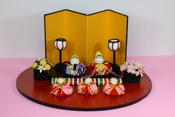 Obraz na płótnie Canvas 着物生地を使って作った、ぼんぼり、橘、桜、の小物にお雛様と三人官女の段飾り
