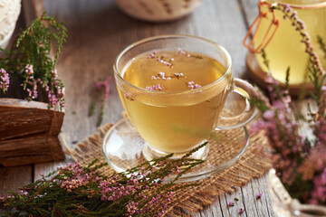 Heather or calluna vulgaris flowers with a cup of herbal tea