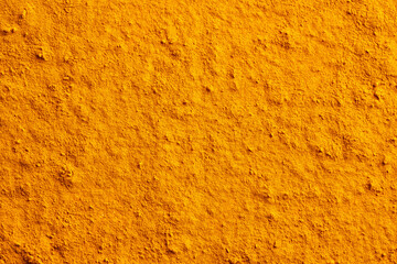 Orange textured background made of dry turmeric powder