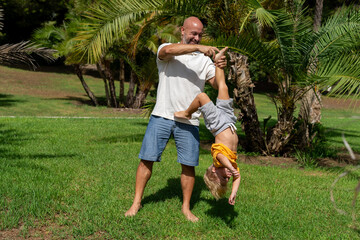 funny father playing with baby feet. . laughter therapy. father tickles his son's legs