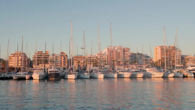 Inside the yacht marina in Torrevieja at sunset. Sailing and motor boats are parking.