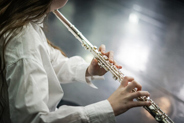 Playing trasverse flute. Close up. 