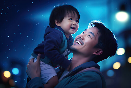 close up shot of father and son. Father giving son ride on back in park. Assian family and blue cloudy sky