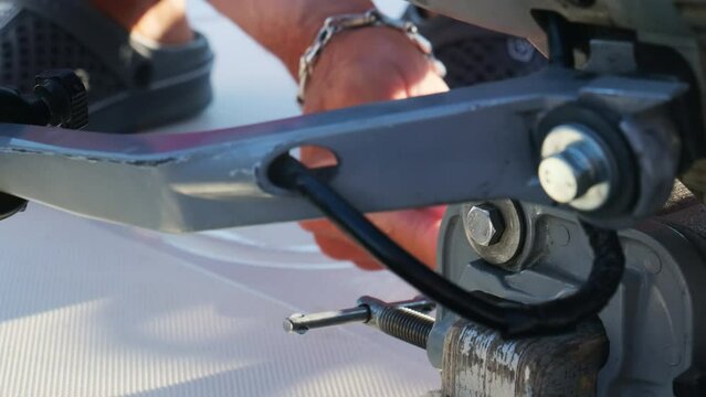 Professional yacht mechanic fixes defects on sailboat closeup. Yachtsman checks technical points on boat for safe vacation