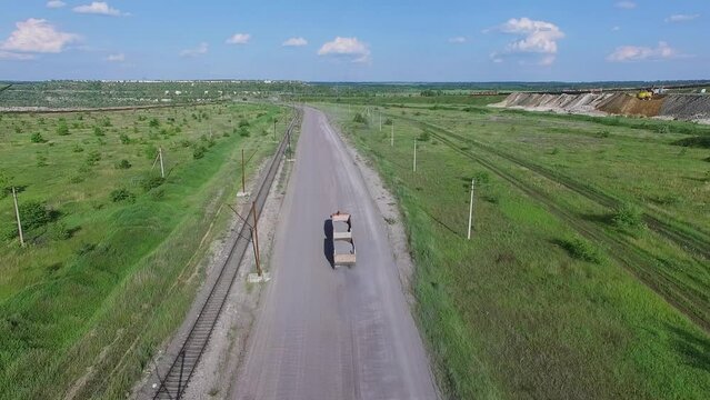 Truck rides by contry road near railway at summer sunny day. Aerial view