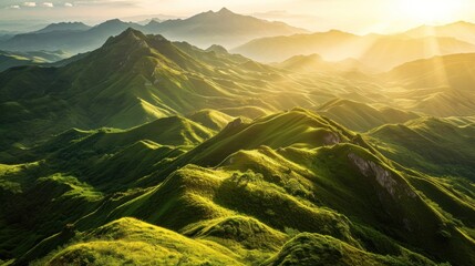 a green mountains with sun shining through the mountains - obrazy, fototapety, plakaty