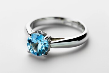 a blue diamond ring on a white surface