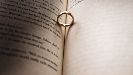 Wedding rings on an open book. Selective focus.