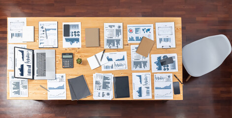 Panoramic top view data analysis dashboard paper on wooden table in meeting room. Paperwork show analytic graph and chart, market trend indication for strategic business investment insights.Meticulous