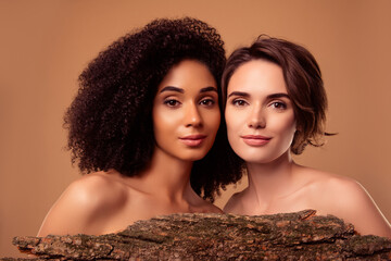 Photo of two people girls spa salon clients applying organic treatment with tree bark over pastel...