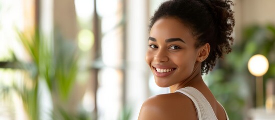 Happy African American woman at home applying nourishing cream or lotion to her shoulder, with copy space.