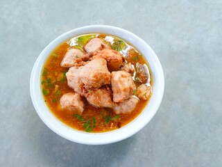 bakso, meatballs served in a bowl on a gray background. Meatball soup with marrow, chicken bones and spring onions without noodles or vermicelli. savory and delicious soupy food.
