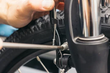 Gordijnen closeup hand of bicycle mechanic adjusting brake © EDER