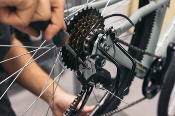 Fototapeta na wymiar closeup mechanic hand adjusting bike gears with screwdriver