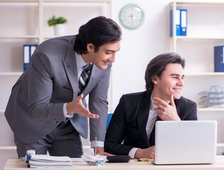 Two young employees working in the office