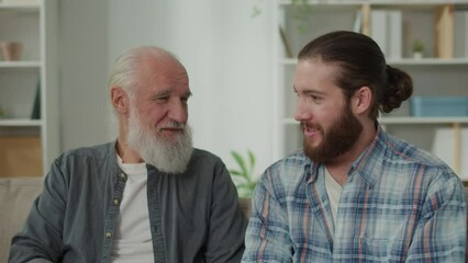 Deep conversation between generations young man and elder on the couch discuss life, experience exchange, heartfelt communication, emotional support, understanding differences mentoring, family values