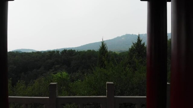Drone fly through a padoga. Panoramic view of woods in China with an old pagoda. Fly inside of chinese pagoda temple in Nanjing, China. Drone video over Purple Zijin mountain. Travel video in asia.