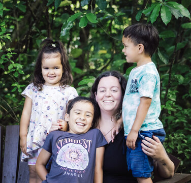 A close up image of a multiracial young family in New Zealand posing for their portrait.