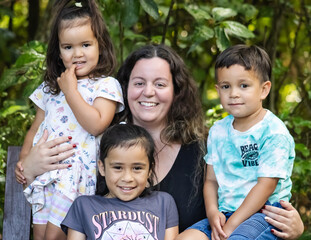 A close up image of a multiracial young family in New Zealand posing for their portrait.