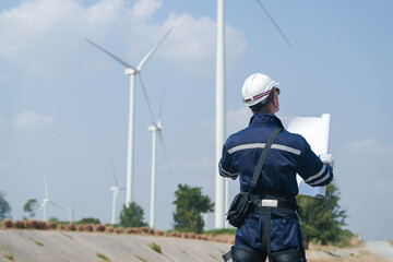 engineers working in fieldwork outdoor. Workers walking and inspect construction and machine around project site. Wind turbine electrical of clean resource enerdy and environment sustainable.