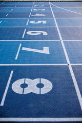 white Numbers on blue running track