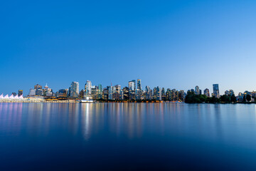 Fototapeta premium A wide-angle long exposure blue hour photo of the Vancouver skyline and Vancouver Harbour from Stanley Park.
