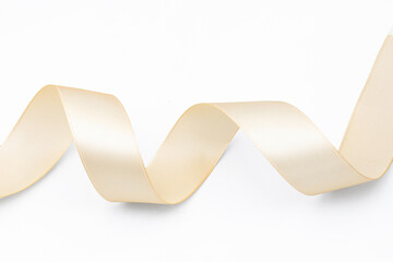 Golden satin ribbol isolated on white. Closeup shiny material ribbon. Cutout material fabric strap....