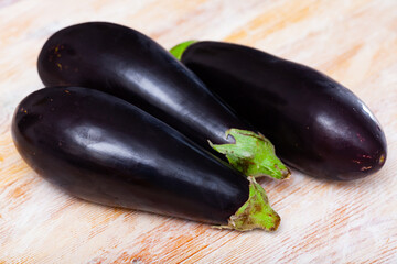 Closeup of fresh eggplants on wooden surface. Healthy vegetarian ingredient