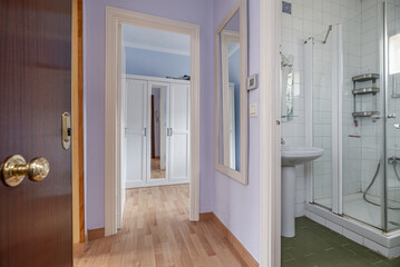 Hallway of a home with oak wood floors, smooth walls painted purple