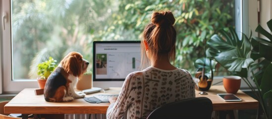 Young female freelancer working from home with her dog, dressed for summer.