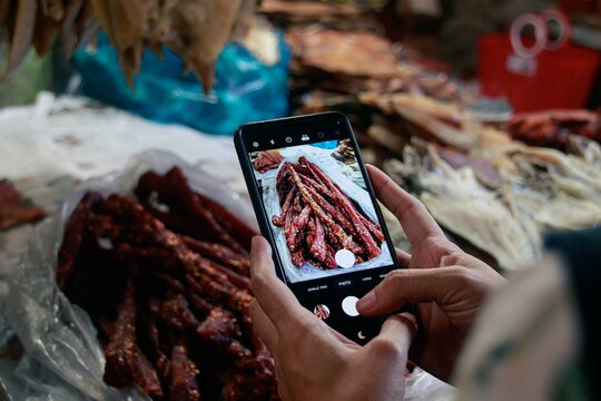 Capturing an image of traditional cambodian beef jerky called sach ko ngeat at the local Samaki Market with a smartphone. Kampot, Cambodia, Asia