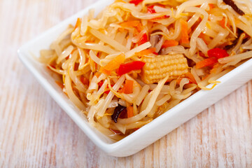 Appetizing marinated salad in Chinese style with shredded cabbage, bean sprouts, young corn cobs and sweet pepper. Healthy vitamin food..