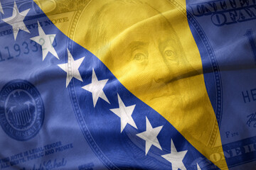 waving colorful flag of bosnia and herzegovina on a american dollar money background. finance concept.