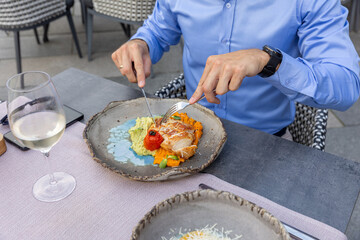Chicken fillet with potato and carrot puree on a plate, ready to be enjoyed with a fork in hand