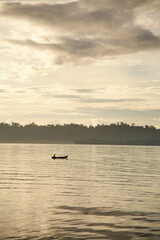 Silo of a small wooden canoe on the ocean at sunset
