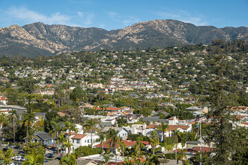 Santa Barbara, CA, USA - November 30, 2023: Santa Barbara County Courthouse lookout tower view on Riviera upscale neighborhood on green hill flank with Santa Ynez mountains and blue sky