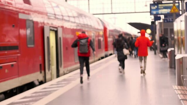 passengers late, running to German railway train, platform Frankfurt am Main station, out of focus video, people with luggage and backpack go to board, boarding travelers in cars, Frankfurt, Germany