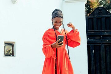 Joyous Young Black African Girl Looking at Mobile Phone