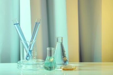 Laboratory analysis. Different glassware on table against color background, space for text