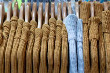 Closeup of sweaters hanging in a retail store.