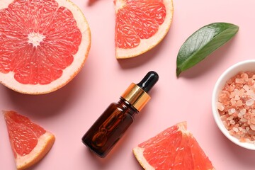 Flat lay composition with grapefruit essential oil on pink background
