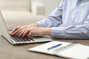 Fototapeta premium E-learning. Woman using laptop during online lesson at table indoors, closeup
