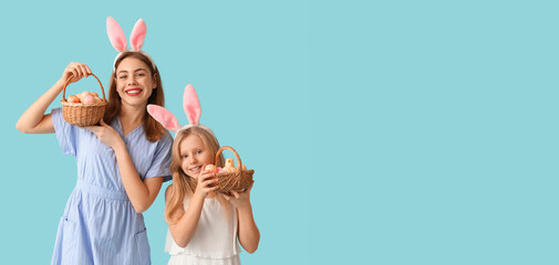 Happy mother and her little daughter with Easter baskets on light blue background with space for text