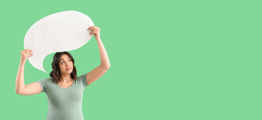 Young pregnant woman holding blank speech bubble on green background with space for text