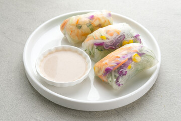 Vegetable spring roll, fresh roll salad made from mix vegetables with shrimp. Served in plate with caesar sauce dressing
